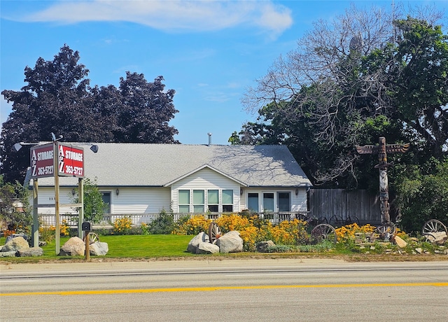 view of front of house featuring a front lawn and fence