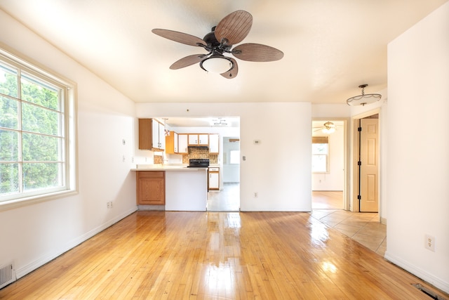 unfurnished living room with ceiling fan, plenty of natural light, and light wood-type flooring