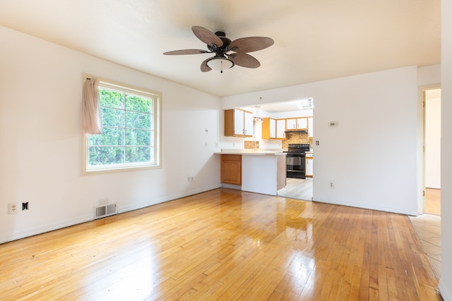 unfurnished living room featuring ceiling fan and light hardwood / wood-style flooring