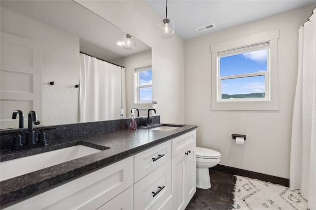 bathroom featuring a wealth of natural light, tile patterned flooring, vanity, and toilet