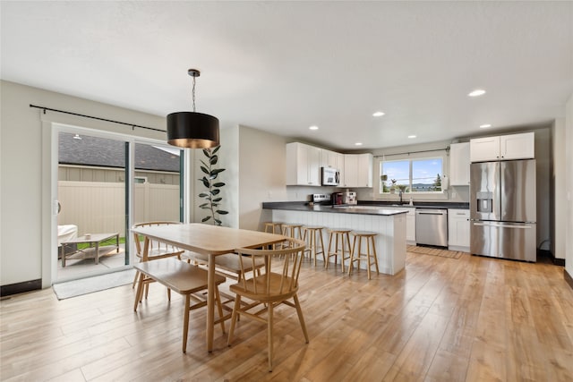 dining space featuring sink and light hardwood / wood-style flooring