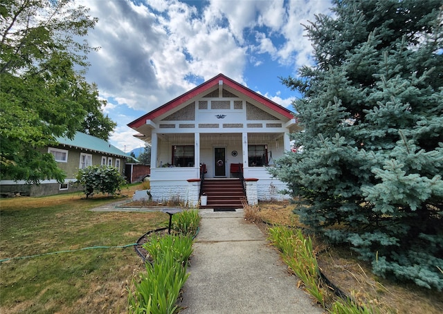 view of front of property with covered porch and a front yard