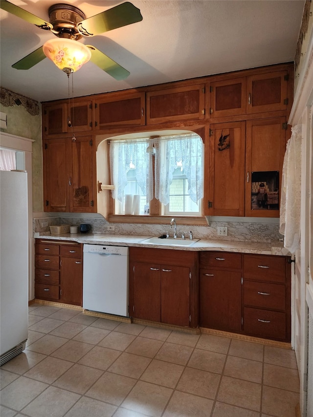 kitchen with ceiling fan, white appliances, sink, and light tile patterned floors