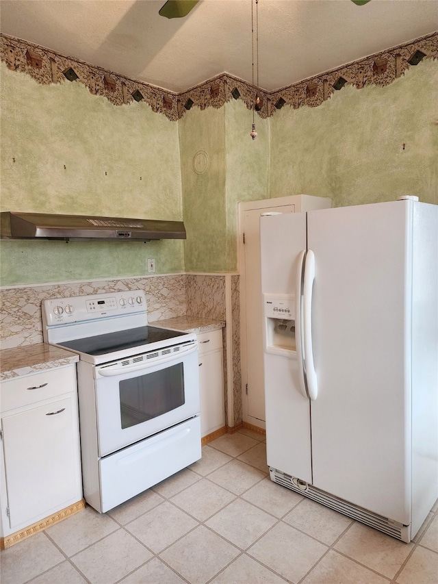 kitchen with white cabinets, light tile patterned floors, white appliances, and ventilation hood