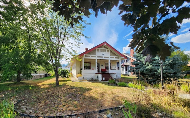 view of front of property with covered porch and a front yard