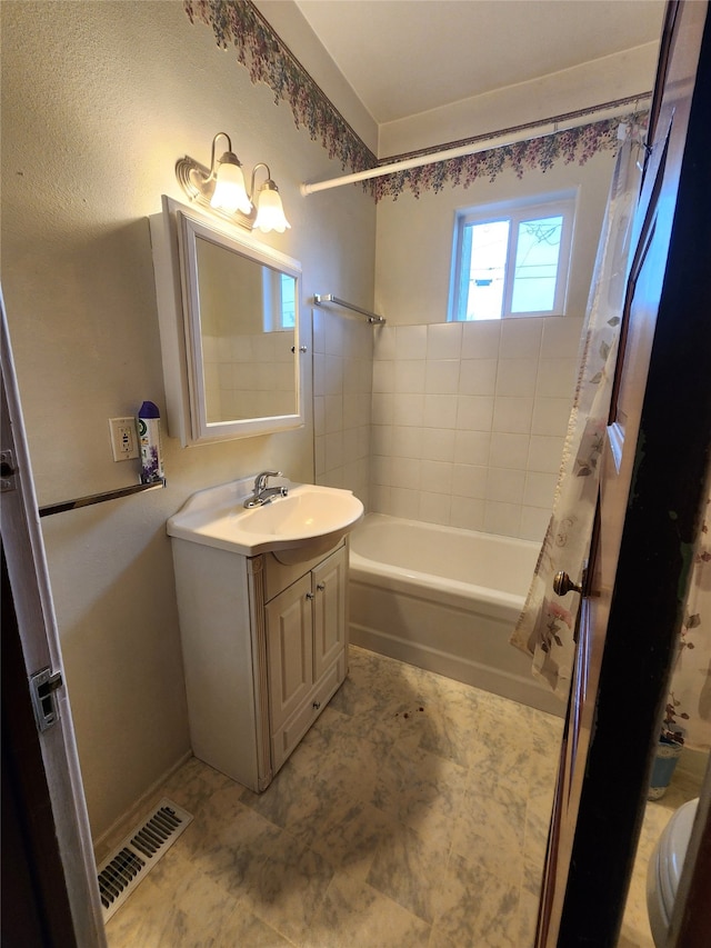 bathroom featuring vanity and shower / bathtub combination with curtain