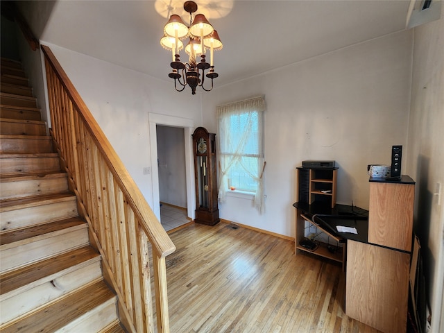 stairway with a chandelier and wood-type flooring