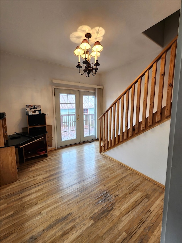 entryway with wood-type flooring, french doors, and a chandelier