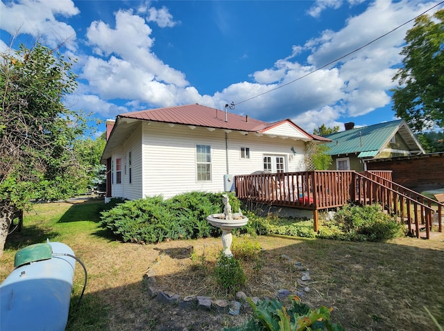 back of property featuring a lawn and a wooden deck