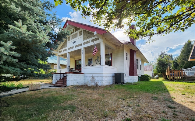 view of front of house with cooling unit, covered porch, and a front yard