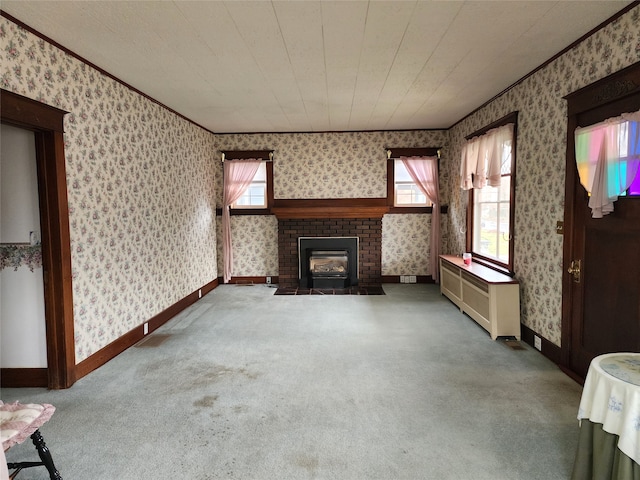 unfurnished living room featuring carpet flooring and a brick fireplace