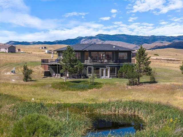 rear view of house featuring a deck with mountain view and stairs