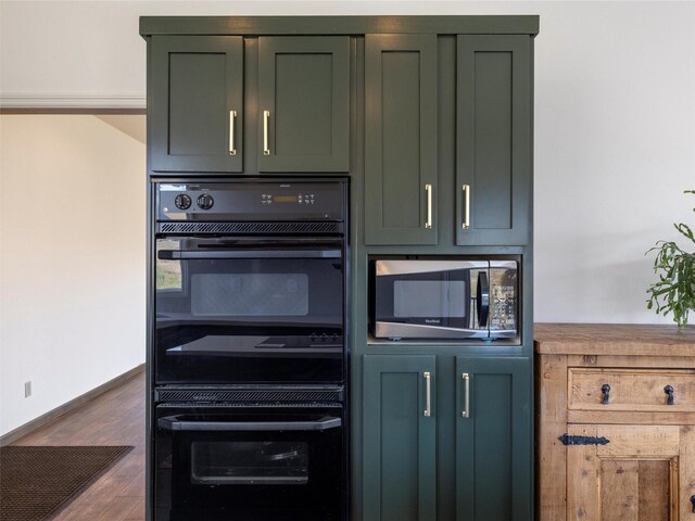 kitchen featuring green cabinetry, dark hardwood / wood-style flooring, and black double oven