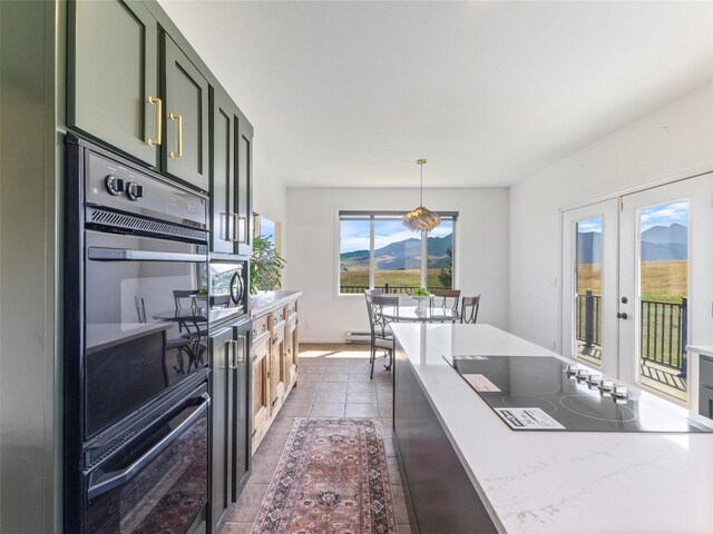 kitchen featuring green cabinets, black oven, dark tile patterned floors, and stainless steel microwave