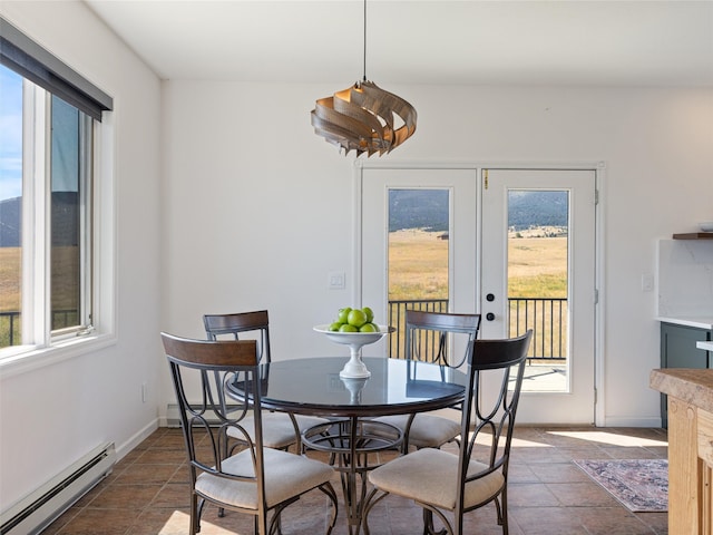 tiled dining area featuring plenty of natural light, baseboard heating, and french doors