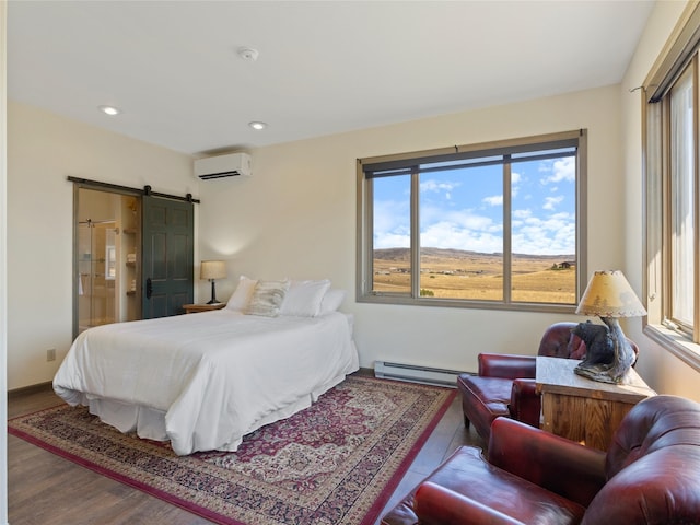 bedroom featuring a baseboard radiator, a wall unit AC, wood-type flooring, and a barn door