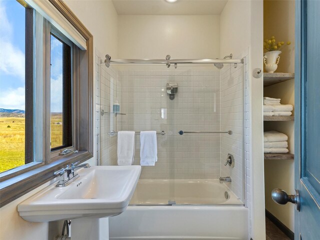 bathroom featuring sink and shower / bath combination with glass door