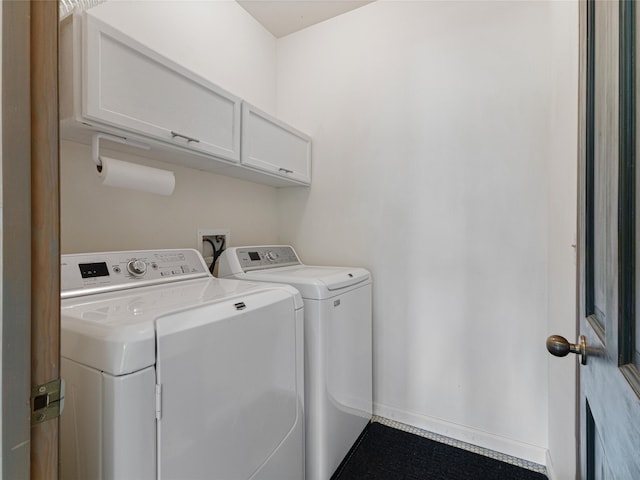 clothes washing area featuring independent washer and dryer and cabinets