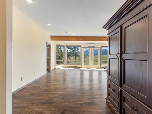 unfurnished living room with beamed ceiling, dark wood-type flooring, and french doors