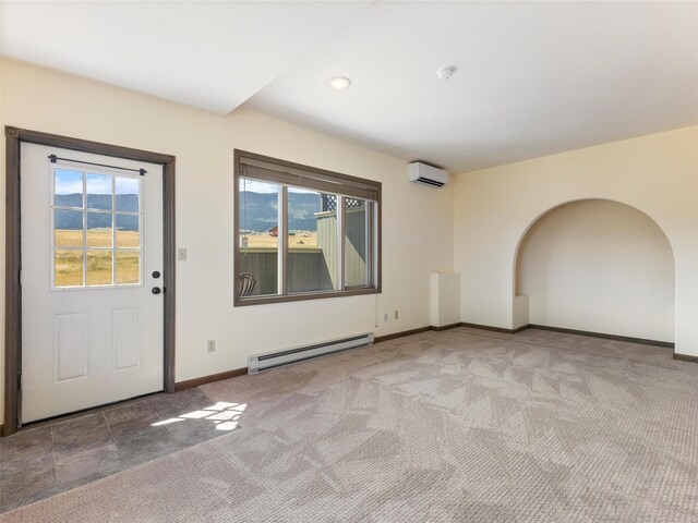 carpeted spare room with a baseboard radiator and a wall unit AC