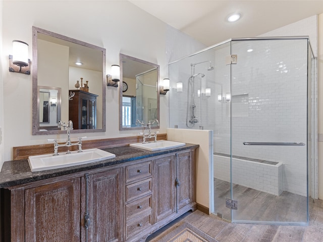 bathroom with a shower with shower door, vanity, and wood-type flooring