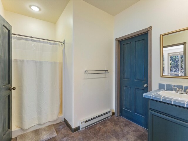 bathroom featuring tile patterned flooring, a baseboard heating unit, shower / bath combo with shower curtain, and vanity