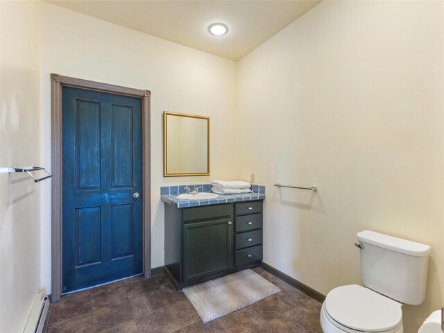 bathroom featuring tile patterned floors, baseboard heating, vanity, and toilet