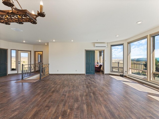 unfurnished living room featuring a wall mounted AC and dark hardwood / wood-style flooring