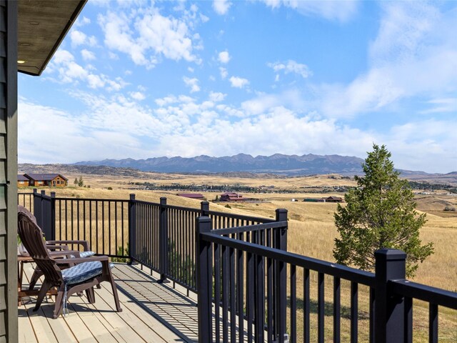 deck with a rural view and a mountain view