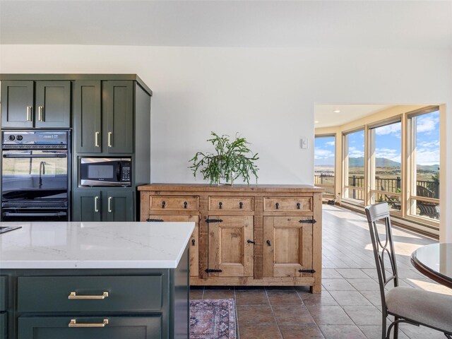 kitchen featuring light stone counters, double oven, and tile patterned floors