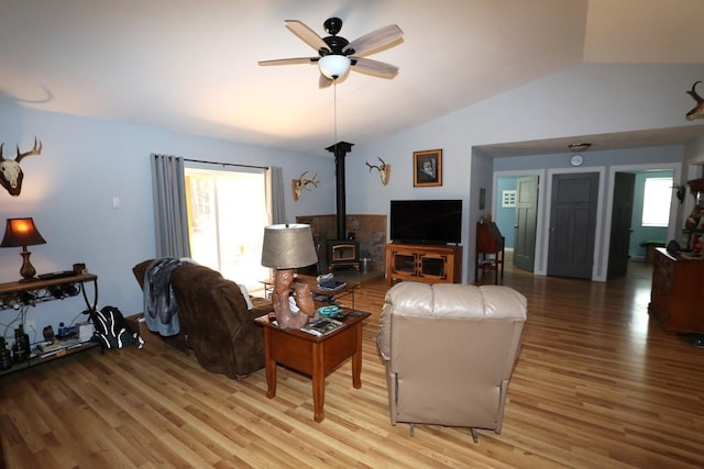 living area with light wood finished floors, ceiling fan, vaulted ceiling, and a wealth of natural light