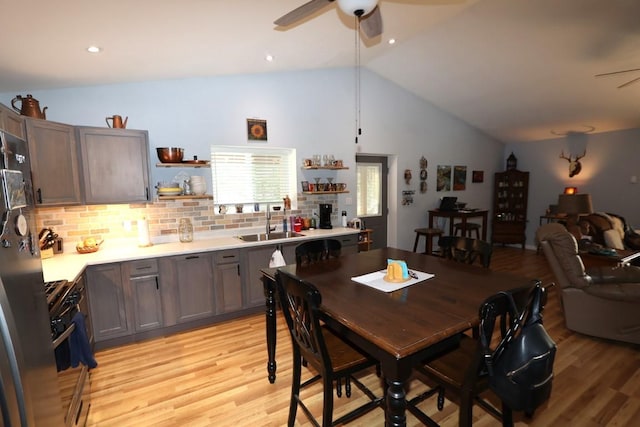 dining room featuring a ceiling fan, lofted ceiling, and light wood finished floors