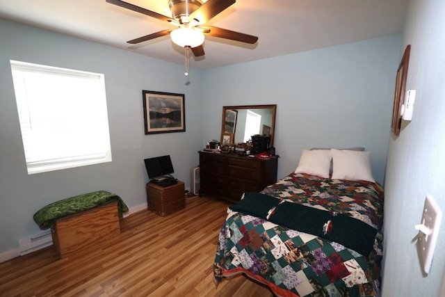 bedroom with light wood-style floors, a baseboard radiator, and a ceiling fan