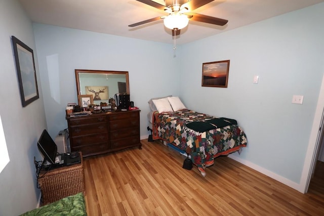 bedroom featuring ceiling fan, baseboards, and wood finished floors