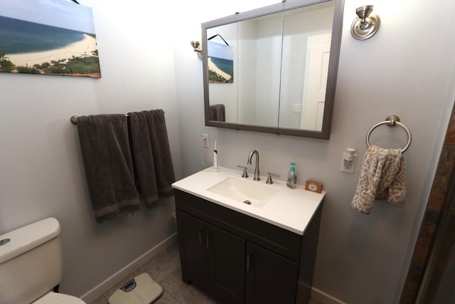 bathroom featuring vanity, toilet, and baseboards