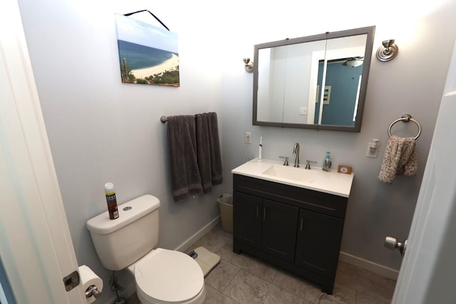 bathroom featuring toilet, tile patterned floors, baseboards, and vanity