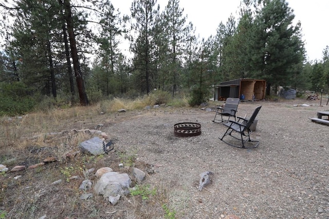 view of yard with an outdoor fire pit and an outdoor structure