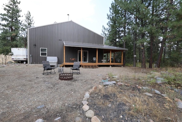 back of property with a deck and a fire pit