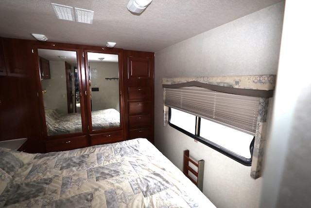 bedroom featuring visible vents and a textured ceiling