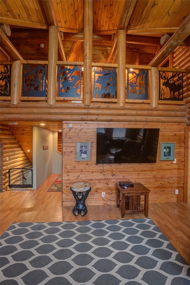 living room featuring beamed ceiling, hardwood / wood-style flooring, log walls, and wooden ceiling