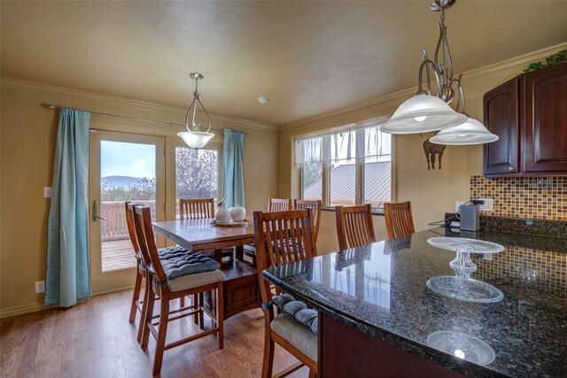 dining area featuring hardwood / wood-style flooring and ornamental molding