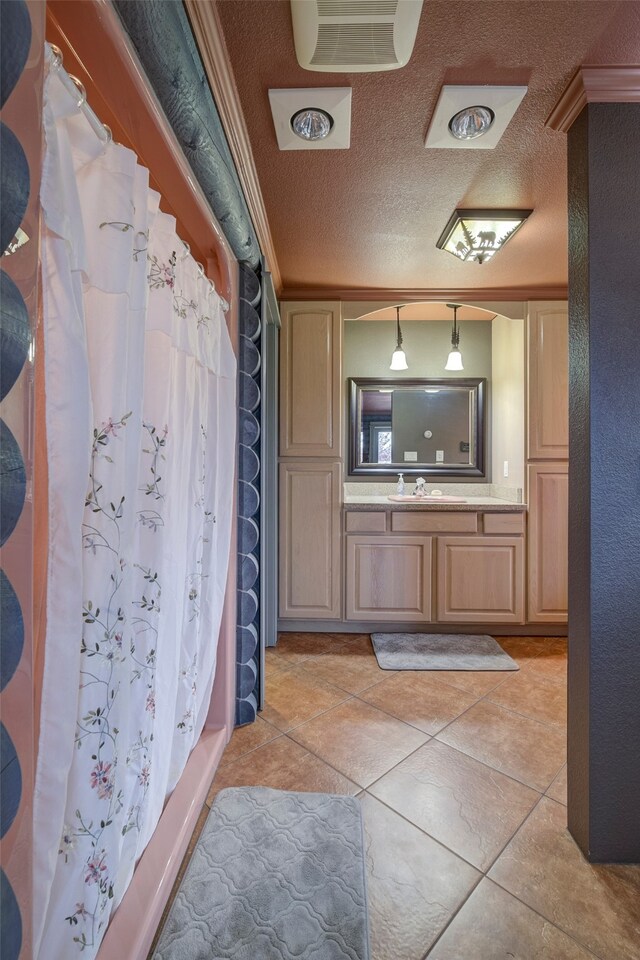 bathroom with a shower with shower curtain, vanity, a textured ceiling, and tile patterned floors