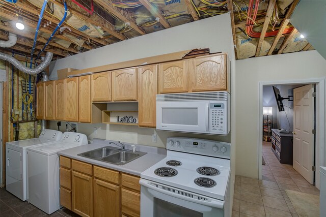 kitchen featuring tile patterned flooring, white appliances, sink, and washer and dryer