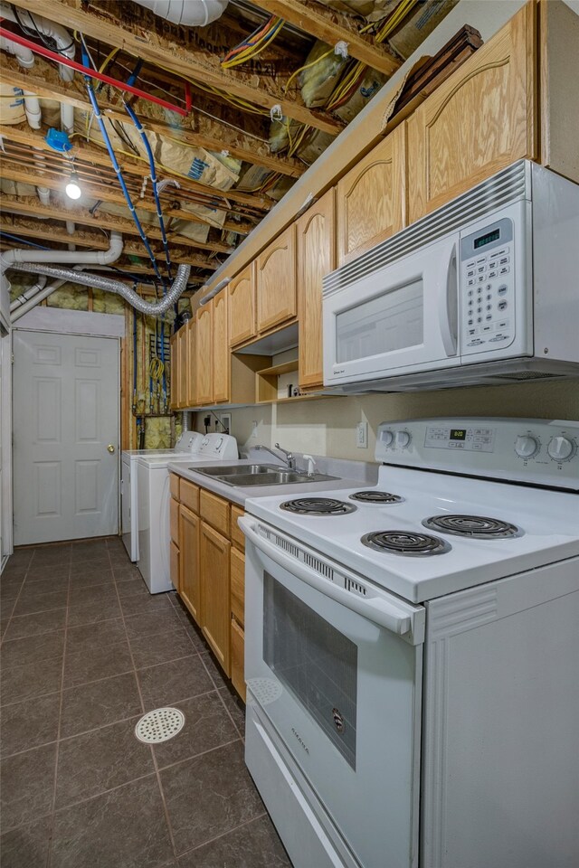 kitchen with decorative light fixtures, dark tile patterned floors, white appliances, separate washer and dryer, and sink