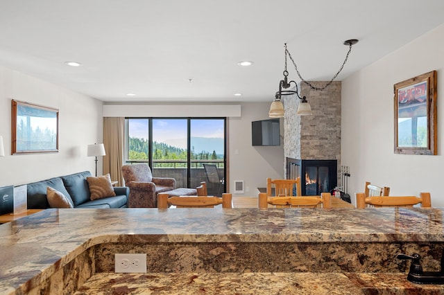 kitchen with stone counters, a fireplace, visible vents, and recessed lighting