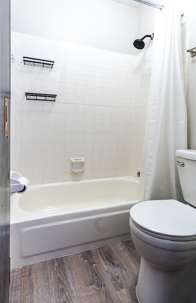 bathroom with toilet, wood-type flooring, and shower / bath combo