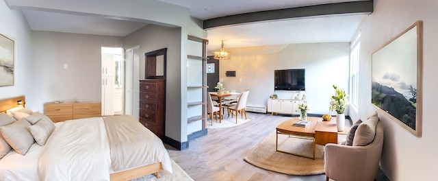 bedroom with light hardwood / wood-style floors, a baseboard heating unit, lofted ceiling with beams, and an inviting chandelier