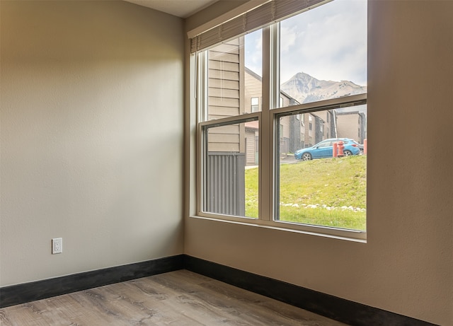 spare room featuring a mountain view and hardwood / wood-style flooring