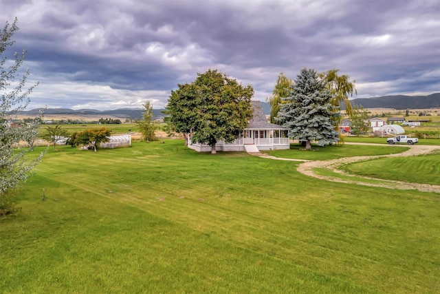 view of yard featuring a mountain view and a porch