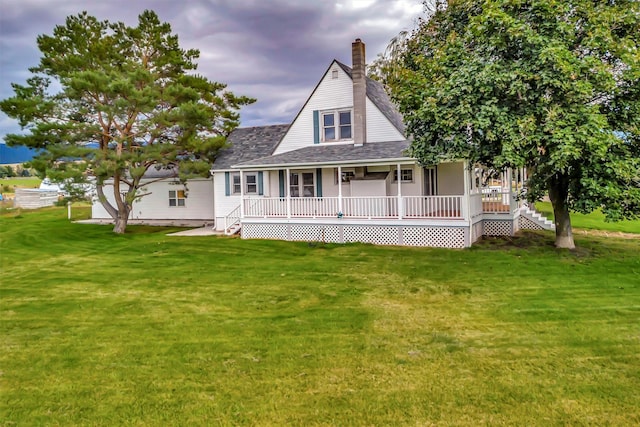 rear view of property with covered porch and a lawn